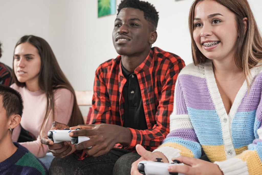 Des adolescents passent du bons temps sur des jeux vidéos.